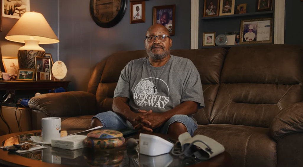 Man sitting on couch with a serious expression on his face.