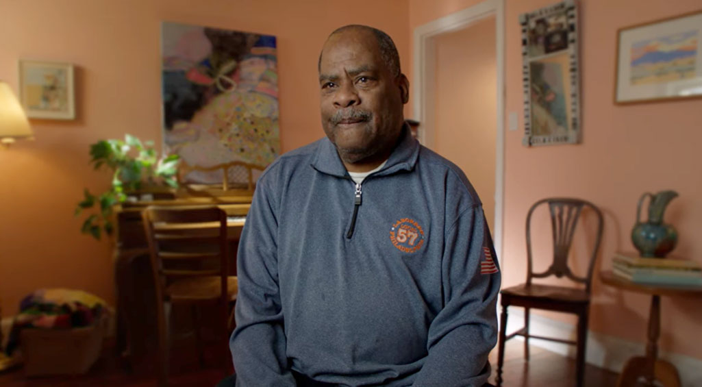 Man sitting in his living room talking about his Monogram Health experience.