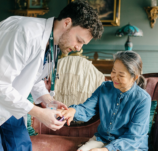 Healthcare provider with an elderly patient in patients living room.