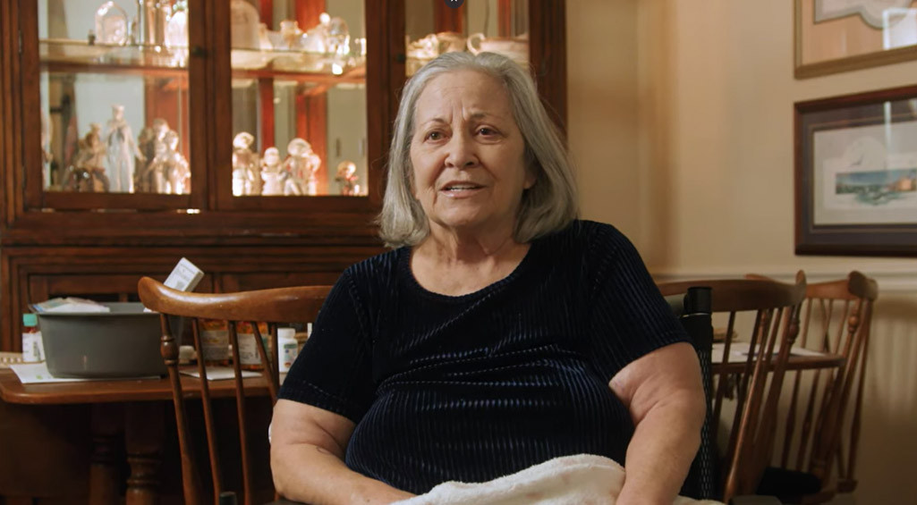 Monogram Health patient sitting in a chair in her living room.